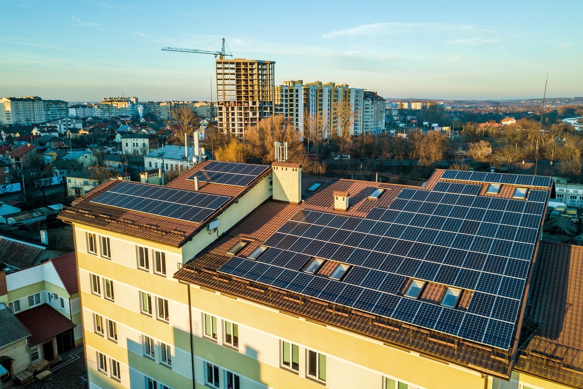 placas solares en edificio de ciudad con obras de fondo